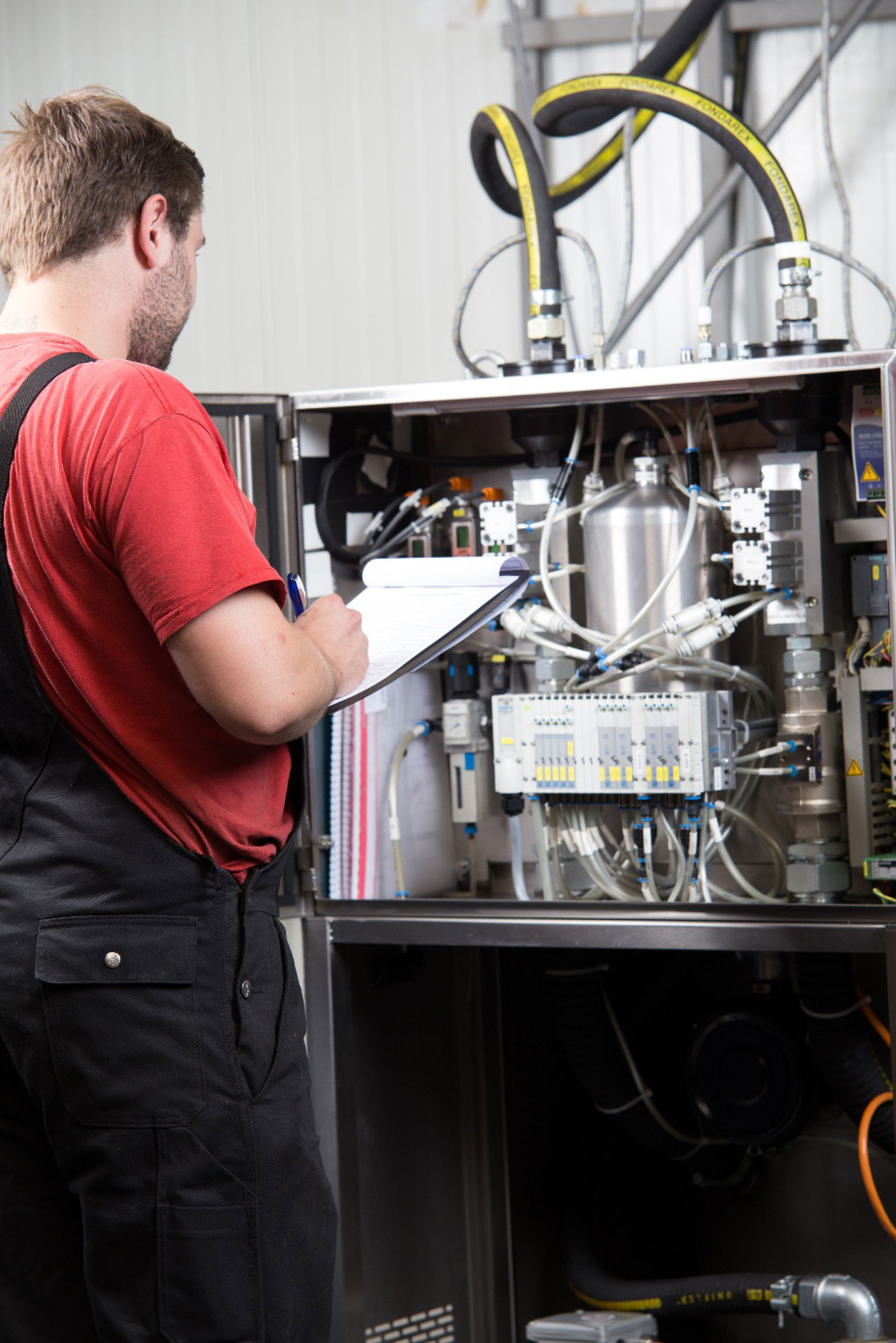 Servicetechniker dokumentiert seine Arbeiten während Wartung, Reparatur und Service an einer Vakuumanlage bei FIMRO